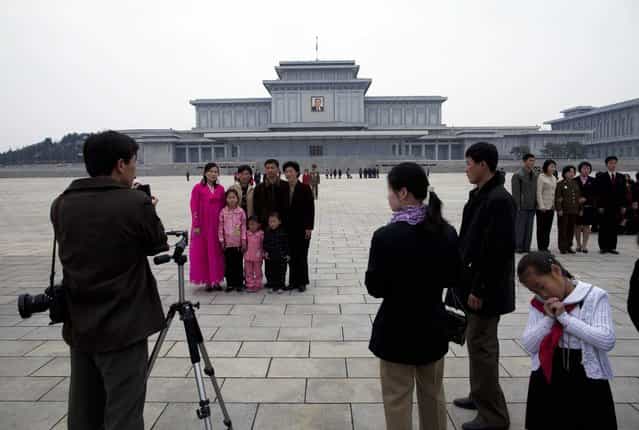 In this April 15, 2011 photo, families have their photographs taken in front of the Kumsusan Memorial Palace in Pyongyang, North Korea. The palace, which was the official residence of Kim Il Sung until his death in 1994, is now a mausoleum where his embalmed body lies in state. (Photo by David Guttenfelder/AP Photo)