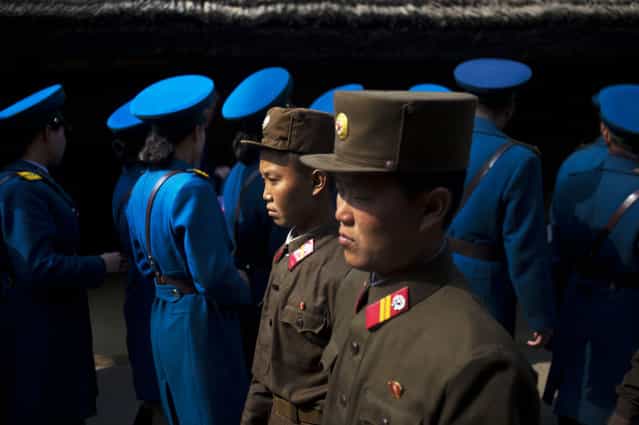 In this April 13, 2011 photo, North Korean soldiers, foreground, and North Korean traffic police, background, tour the birthplace of Kim Il Sung to pay their respects at Mangyongdae, North Korea. (Photo by David Guttenfelder/AP Photo)