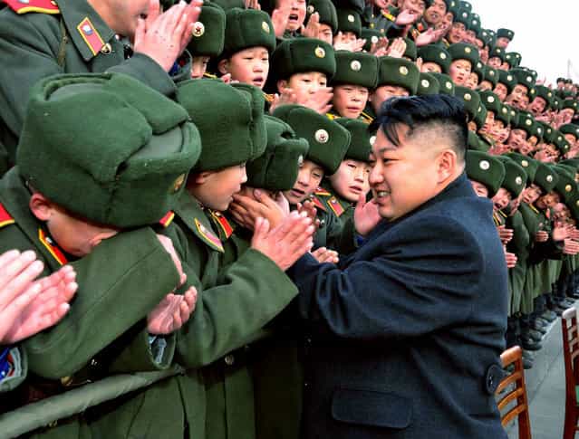 This picture taken by North Korea's official Korean Central News Agency shows North Korean leader Kim Jong Un greeting students during a visit to the Mangyongdae Revolutionary School on January 23, 2012. (Photo by AFP Photo/KNS)
