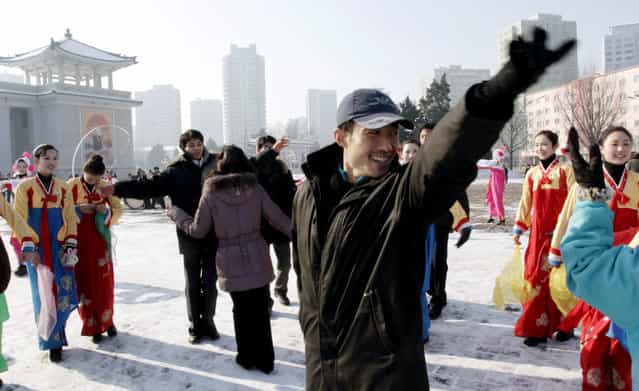 In this Wednesday, December 12, 2012 file photo, North Korean youths dance before the Pyongyang Grand Theatre in Pyongyang, North Korea, to celebrate a rocket launch after North Korea successfully fired a long-range rocket. (Photo by Jon Chol Jin/AP Photo)
