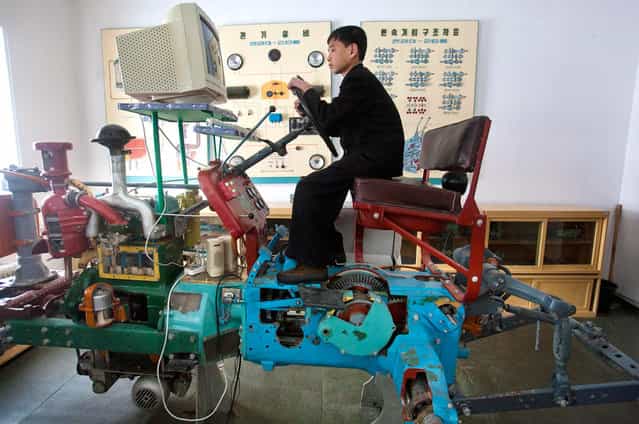 A North Korean student learns to drive a tractor on a computerized driving simulator at the Samjiyon School children's Palace in Samjiyon, North Korea, on April 3, 2012. The facility was built for children to take part in after school programs in the arts, sciences, sports, computer and vocational training. (Photo by David Guttenfelder/AP Photo)
