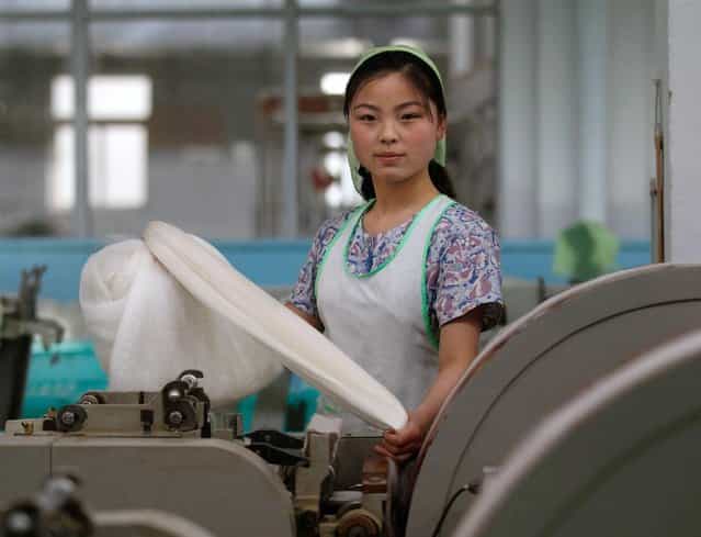 A woman works in the Kim Jong-suk Pyongyang Silk Mill in Pyongyang, on April 9, 2012. (Photo by Bobby Yip/Reuters)