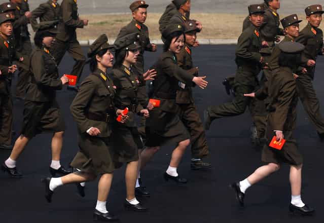 Soldiers run into a stadium to join a ceremony in Pyongyang, on April 14, 2012. (Photo by Bobby Yip/Reuters)