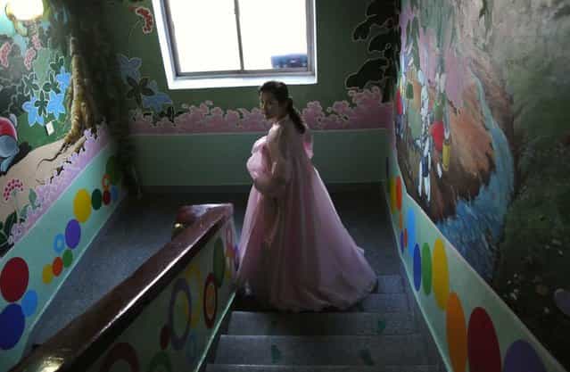 A North Korean teacher walks down a flight of stairs at a nursery school in the northeastern North Korean border town of Sinuiju, on December 15, 2012. (Photo by Wang Zhao/AFP Photo)