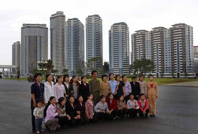 A group of North Koreans pose for a picture near the newly constructed development project area on Mansu Hill in Pyongyang, North Korea Wednesday, September 19, 2012. (Photo by Vincent Yu/AP Photo)