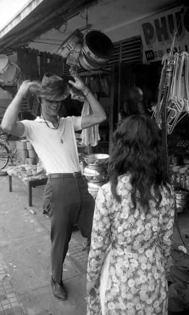 James Farley takes a fancy to a bush hat and models it in the street, Da Nang, March 1961. (Photo by Larry Burrows/Time & Life Pictures)