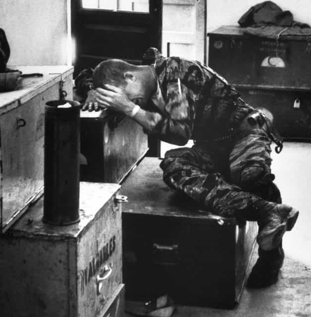 In a supply shack, hands covering his face, an exhausted, worn James Farley gives way to grief. (Photo by Larry Burrows/Time & Life Pictures)
