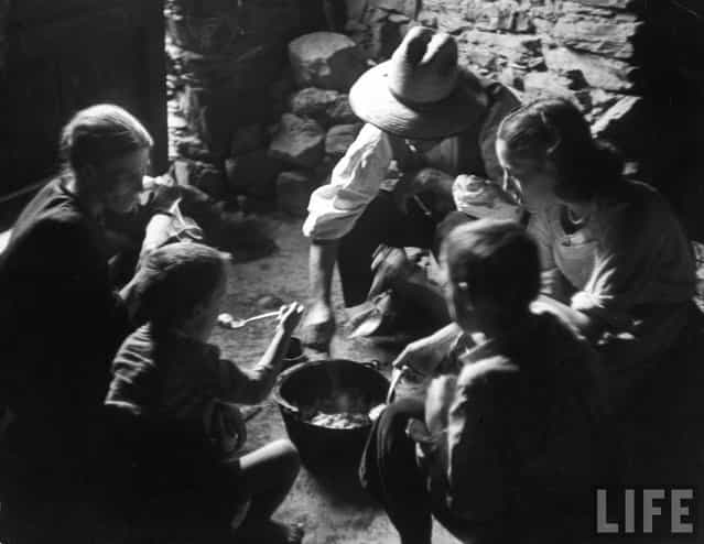 The Curiels eat thick bean and potato soup from common pot on dirt floor of their kitchen. The father, mother and four children all share the one bedroom. (Photo by W. Eugene Smith/Time & Life Pictures)