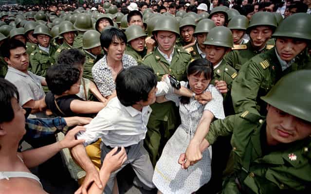 Student protestors, including one girl with a camera, struggle with soldiers from the Chinese Army, the PLA. Tiananmen Square, 1989. (Photo by Jeff Widener/Associated Press)