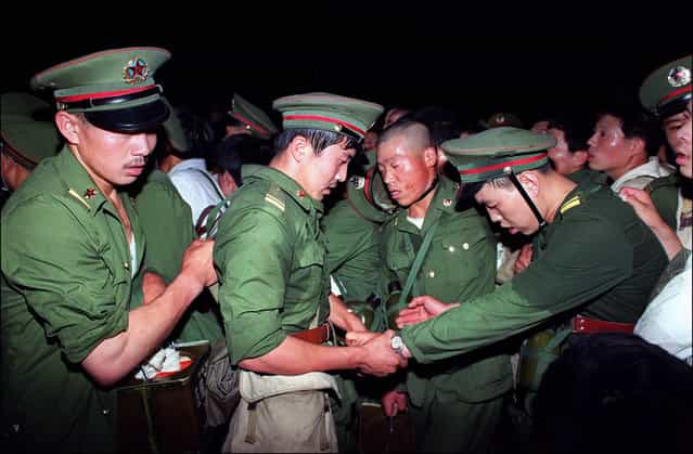 Exhausted, humiliated soldiers are hustled away by protesters in central Beijing, on June 3, 1989. (Photo by Catherine Henriette/AFP Photo)