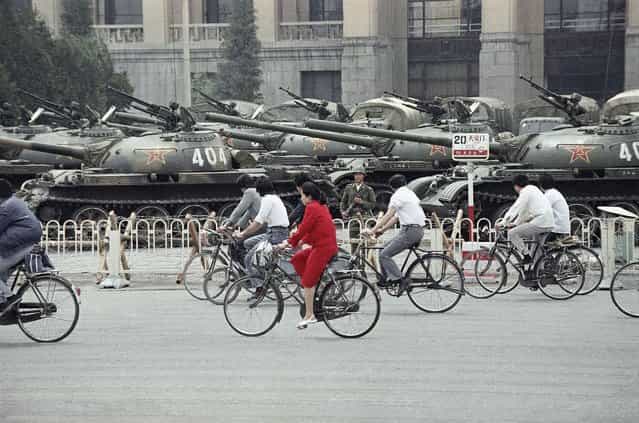A wall of tanks and APCs greet bicycle commuters near Tiananmen Square, on June 13, 1989, in Beijing. (Photo by Sadayuki Mikami/AP Photo)