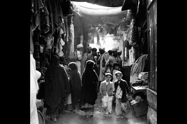 Afghan boys, men, and women, some in bare feet, shop at a marketplace in Kabul, Afghanistan, in May of 1964. (Photo by AP Photo via The Atlantic)