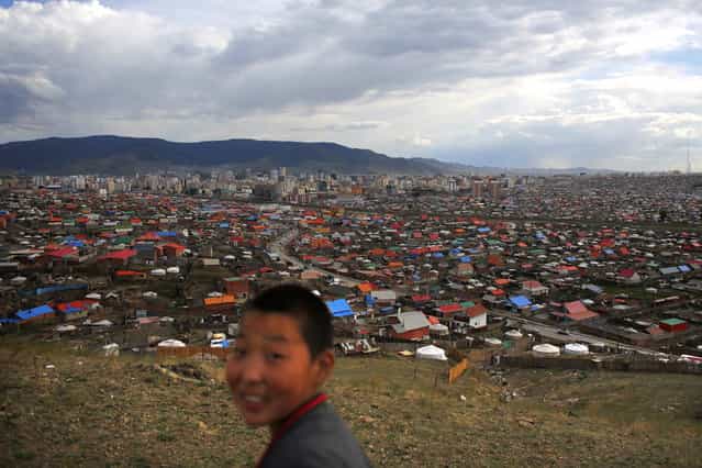 A boy walks at an area known as a ger district, where some residents live in traditional Mongolian tents, in Ulan Bator June 22, 2013. Approximately 60 percent of the population of Ulan Bator live in settlements known as ger districts and in many cases residents have limited access to basic services such as water and sanitation. According to a 2010 National Population Center census, every year between thirty and forty thousand people migrate from the countryside to the capital Ulan Bator. Ger districts in the city have been expanding rapidly in recent years. Mongolia is the world's least densely populated country, with 2.8 million people spread across an area around three times the size of France. (Photo by Carlos Barria/Reuters)