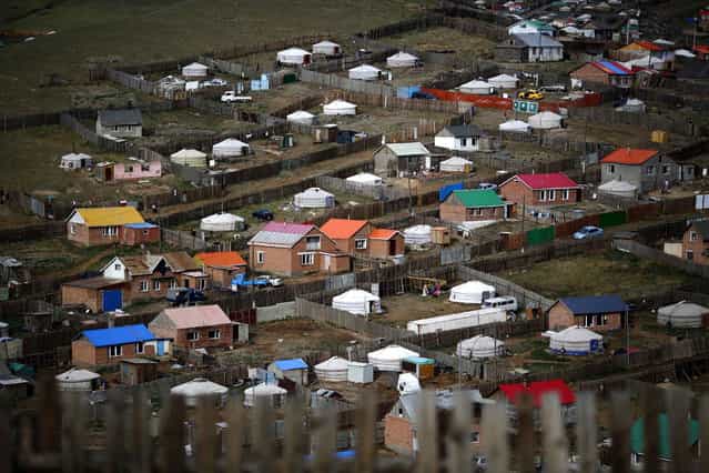 Gers, traditional Mongolian tents, are seen on a hill in an area known as a ger district in Ulan Bator June 22, 2013. Approximately 60 percent of the population of Ulan Bator live in settlements known as ger districts and in many cases residents have limited access to basic services such as water and sanitation. According to a 2010 National Population Center census, every year between thirty and forty thousand people migrate from the countryside to the capital Ulan Bator. Ger districts in the city have been expanding rapidly in recent years. Mongolia is the world's least densely populated country, with 2.8 million people spread across an area around three times the size of France. (Photo by Carlos Barria/Reuters)