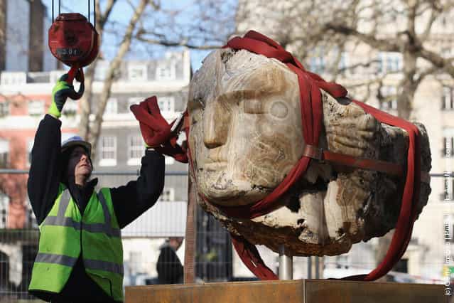 Giant Stone Heads Created By British Sculptor Emily Young Are Winched Into Berkeley Square