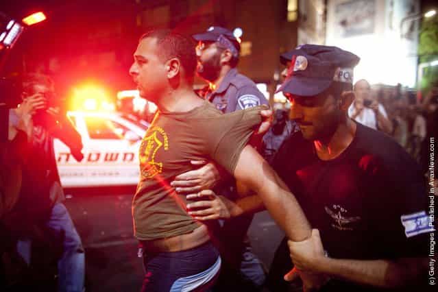 Israeli police officers arrest a demonstrator as Israelis protest against rising housing prices and social inequalities on July 30, 2011 in Tel Aviv, Israel