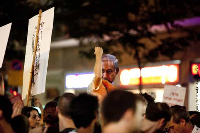 An Israeli man wears a mask of Israels Prime Minister Benjamin Netanyahu during a protest against rising housing prices and social inequalities on July 30, 2011 in Tel Aviv, Israel