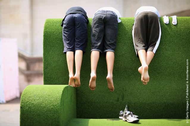 Young boys lean over a giant sofa on the South Bank