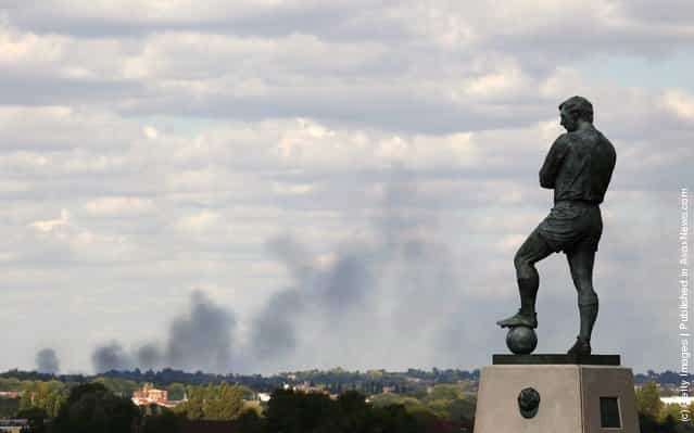 Smoke is seen over north London from a view behind the Bobby Moore statue outside Wembley Stadium as the England v Netherlands game is called off at Wembley Stadium following a night of rioting on August 9, 2011 in London, England