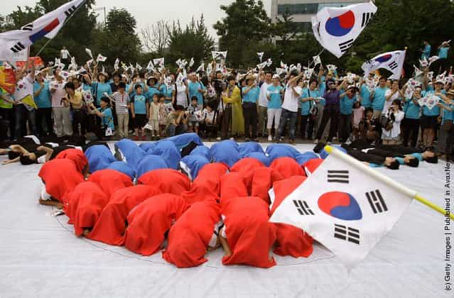 South Koreans wave national flags during the 66th Independence Day ceremony in Seoul, South Korea