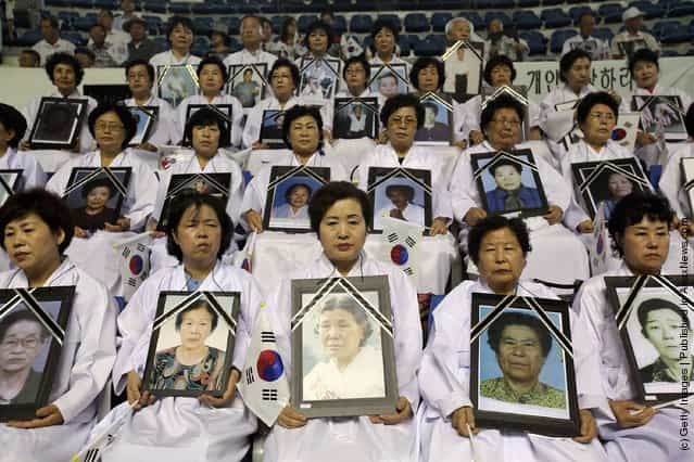 South Korean family members of victims of the World War II hold portrait of their loved one during the 66th Independence Day ceremony in Seoul, South Korea