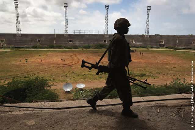 A Ugandan soldier, part of the 9,000-strong African Union Mission in Somalia, (AMISOM) walks through the Banadir soccer stadium in Mogadishu, Somalia