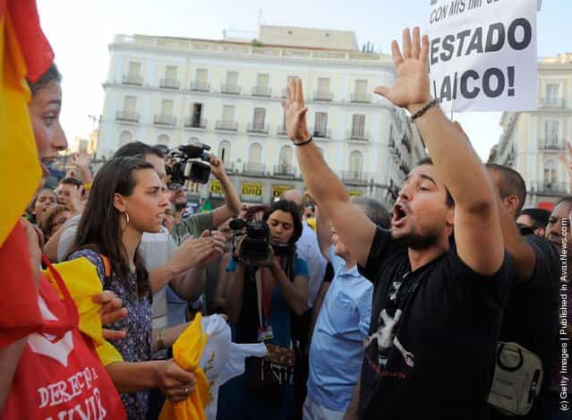 Pro (L) and anti World Youth Day supporters face off at Puerta del Sol square during a march against the papal events taking place