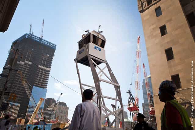 People walk underneath a New York Police Department mobile observation tower outside of Ground Zero