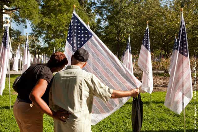 Rivera Leo, from New York, reads names on a flag in the Rembrance Field of Honor, an installation of flags in Battery Park, in memory of the victims of the terrorist attacks on September 11, 2001