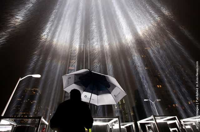 A worker holds an umbrella while adjusting beams of the Tribute in Lights ahead of the tenth anniversary of the September 11 terrorist attacks