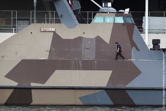 A sailor walks on the deck of a Skjold class missile fast patrol of the Royal Norwegian Navy at anchor next to the ExCeL exhibition centre