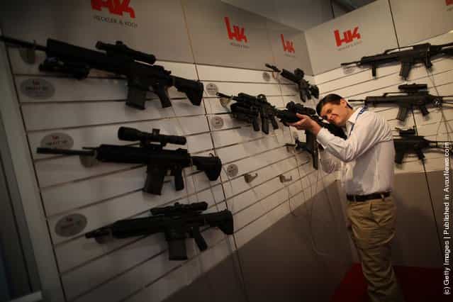 A visitor tries out a Heckler and Koch assault rifle at the Defence and Security Exhibition
