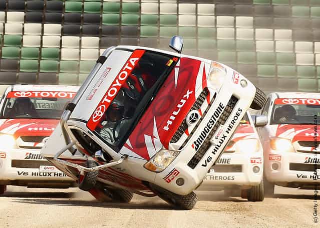 A car is driven on two wheels by the team from Toyota V6 HiLux Heroes during a Royal Melbourne Show