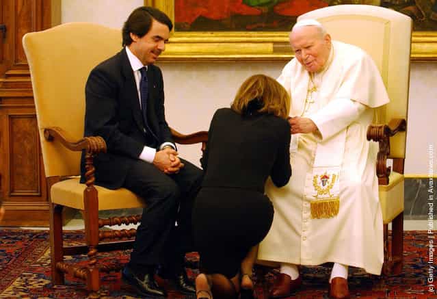 Spanish Prime Minister Jose Maria Aznar watches as his wife, Spanish First Lady Ana Botella Aznar, kneals before Pope John Paul II