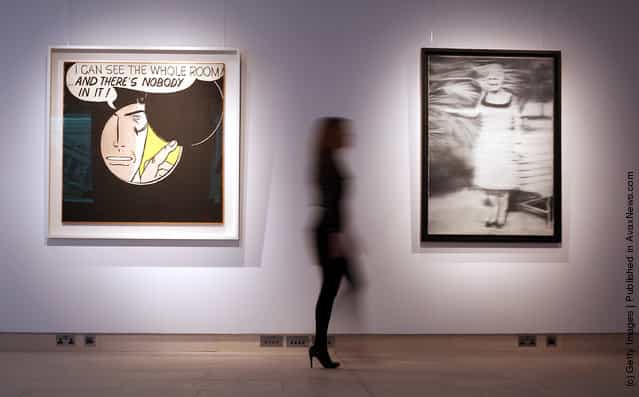 A Christie's employee walks between Roy Lichtenstein's 'I Can See the Whole Room... and There's Nobody in It' (L) and Gerhard Richter's Frau Niepenberg