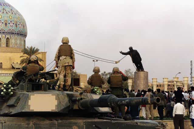 U.S marines and Iraqis are seen as the statue of Iraqi dictator Saddam Hussein is toppled at al-Fardous square in Baghdad