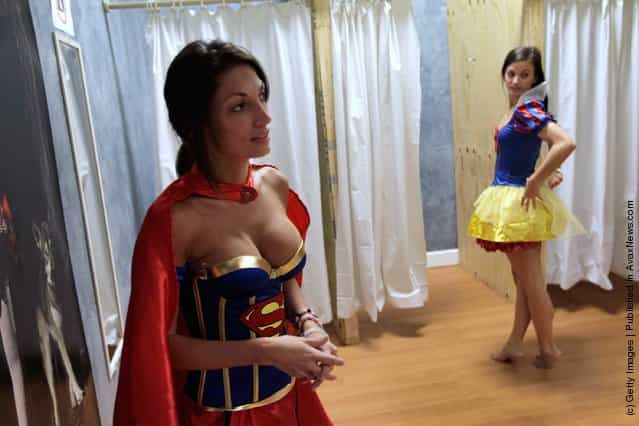 Gina Labianca (L) tries on a super woman outfit as Charlie Lucas tries a snow white Costume at the Halloween MegaStore
