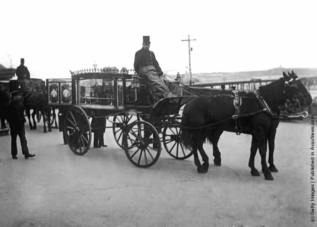 Pallbearers attend a glass sided funeral carriage in Portsmouth, circa 1900