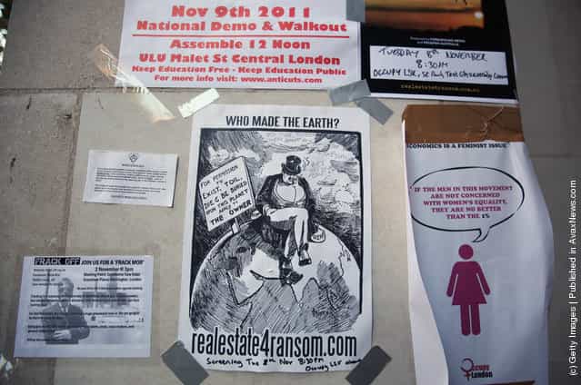 Protest posters are attached to the walls surrounding the Occupy London camp outside St. Pauls Cathedral