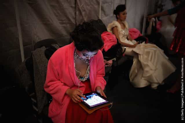 A model looks at her ipad before Tsai Meiyue Wedding Dress S/S 2012 of China Fashion Week Spring/Summer 2012