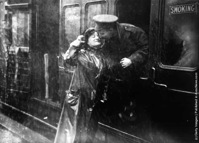 A soldier saying goodbye to a loved one in the rain at Victoria station, London, as he leaves for the front