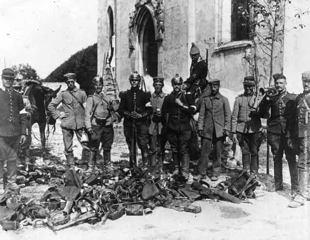 French soldiers wearing German helmets stand with equipment captured from the enemy troops after the Battle of the Marne in WWI
