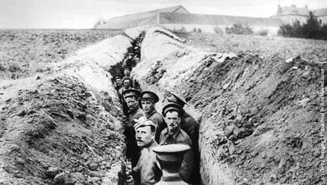 British soldiers lined up in a narrow trench during World War I