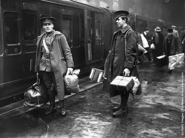 1914: Two soldiers on the concourse at Victoria station, London, about to leave for the front line. They are carrying parcels full of food and other provisions