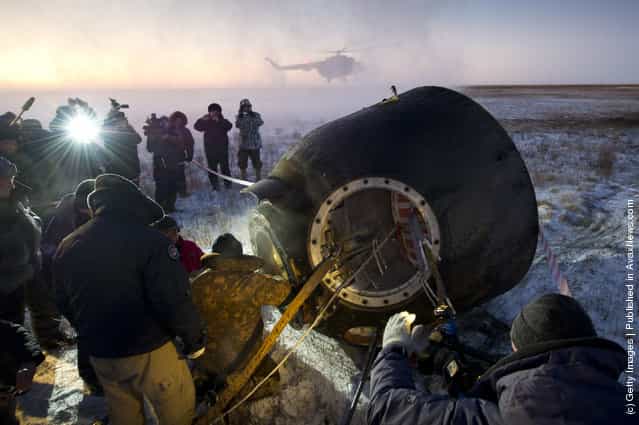 Russian support personnel work to help get Expedition 29 crew members out of the Soyuz TMA-02M spacecraft shortly after the capsule landed