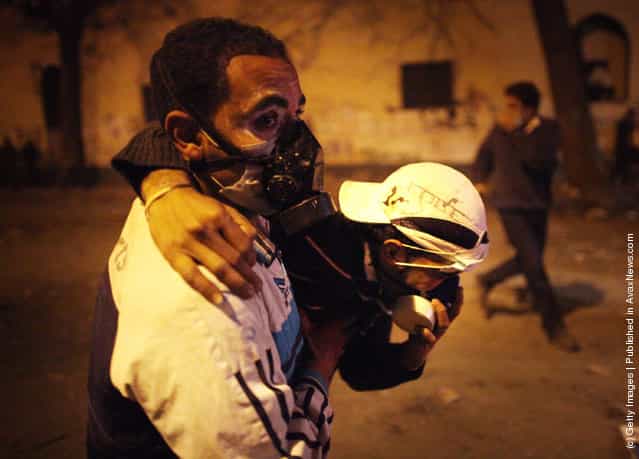 A prototestor helps another suffering from the effects of tear gas near Tahrir Square