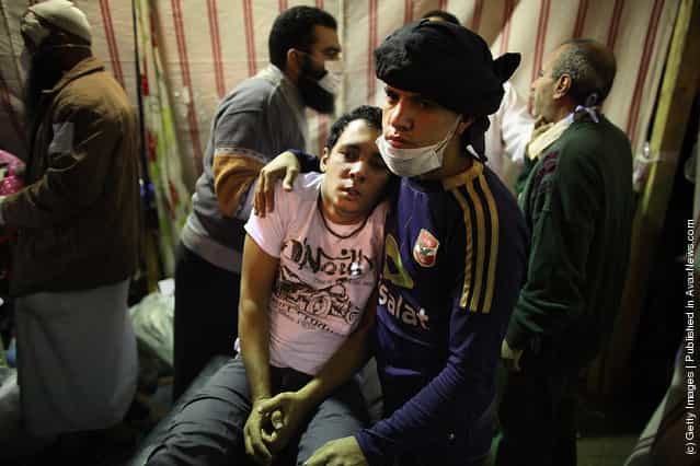 A protestor suffering from the effects of tear gas is comforted in a make shift medical centre in Tahrir Square