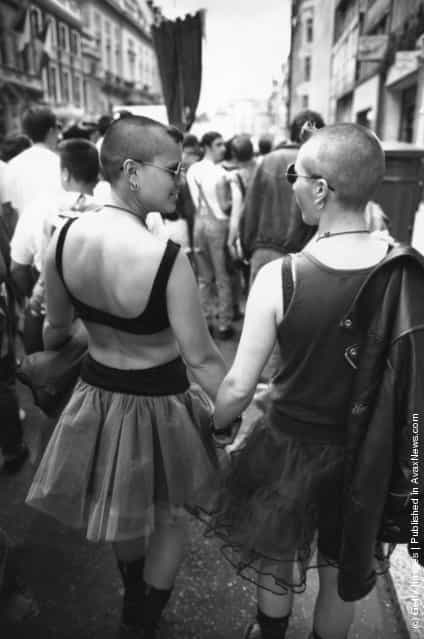 A lesbian couple hold hands during the annual Gay Pride march through central London, July 1993