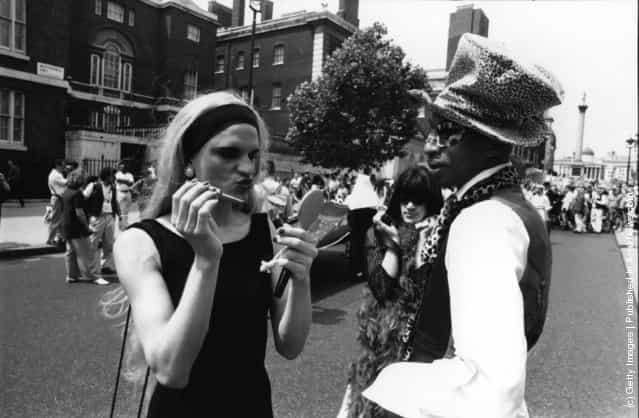 A transvestite adjusts his make-up at the annual Gay Pride march, promoting gay and lesbian rights, London, July 1994