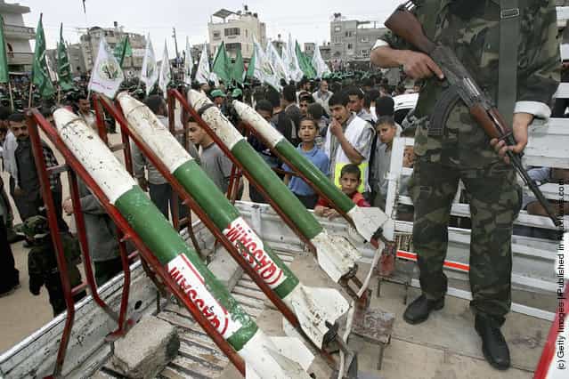 Masked Palestinian members of Al-Qassam Brigades the military wing of the Islamic Resistence Movement (HAMAS) show homemade Qassam Rockets